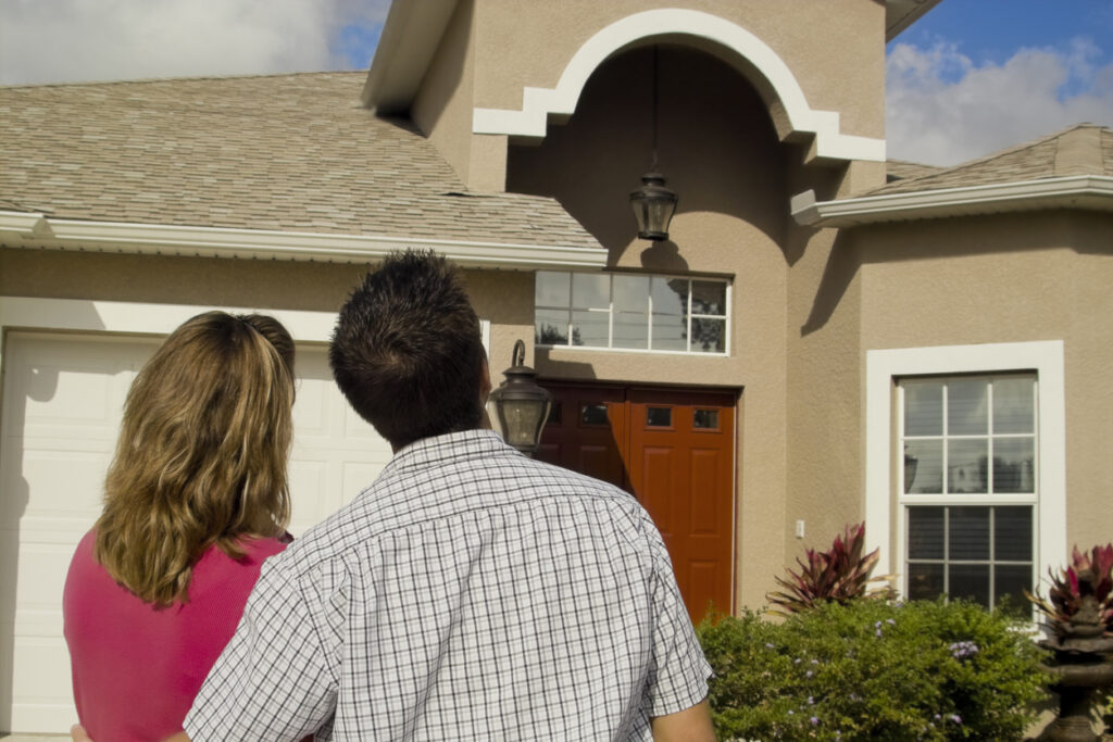 A couple gazing proudly at their brand new roof repair.