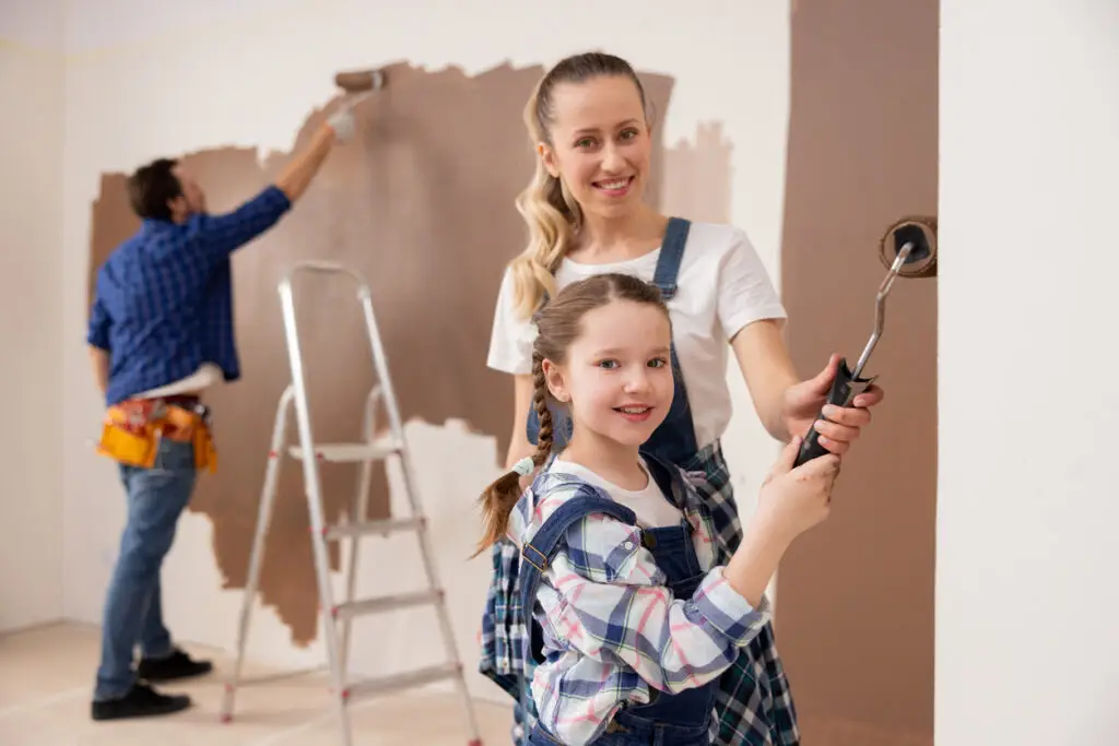 Exterior and Interior Painting with Mother and child. Father behind them painting.